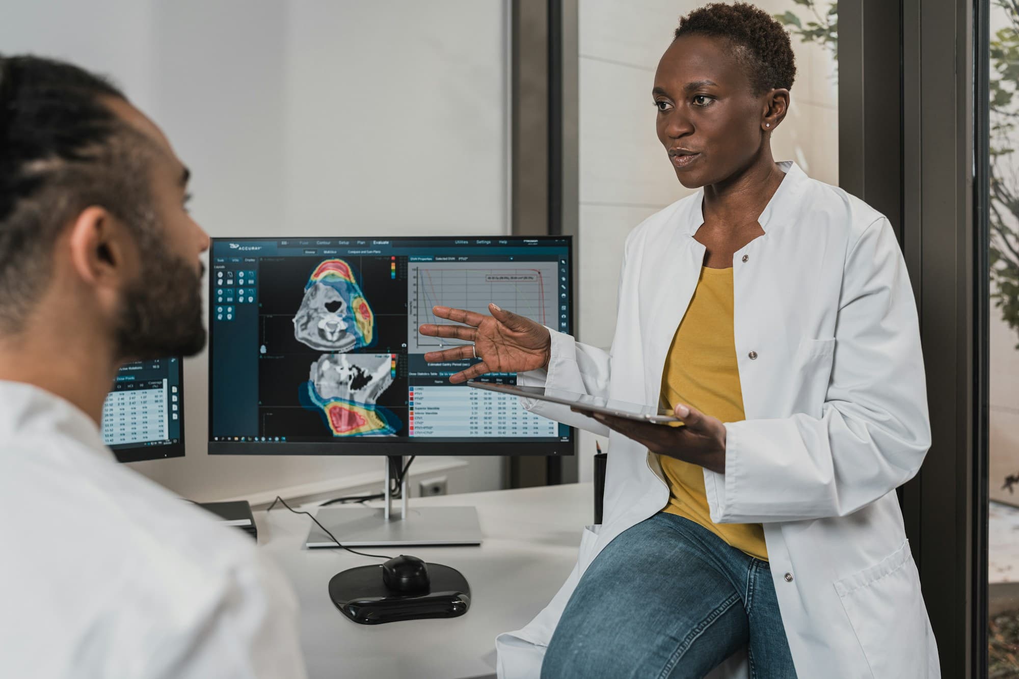 Doctor reviewing care plans on a tablet in a modern clinic
